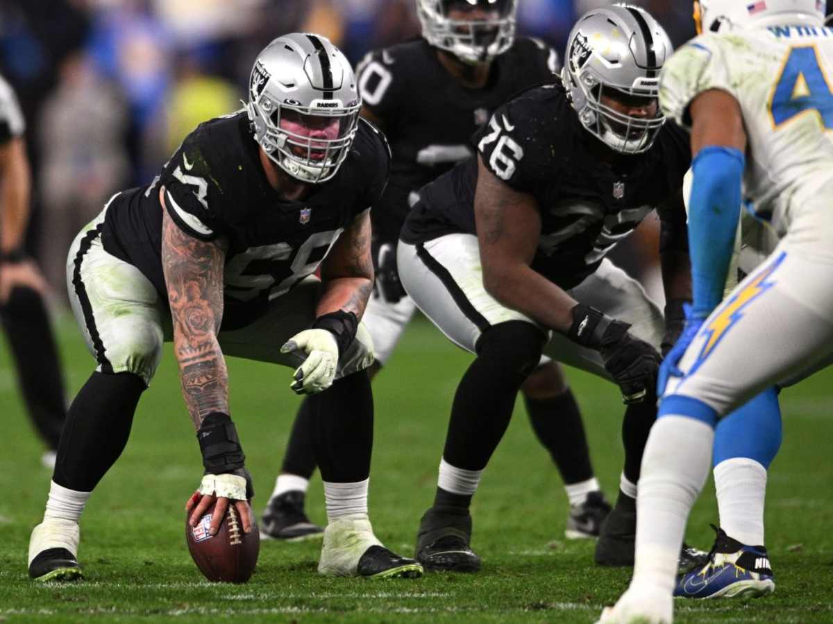 Las Vegas Raiders center Andre James walks with trainers after an