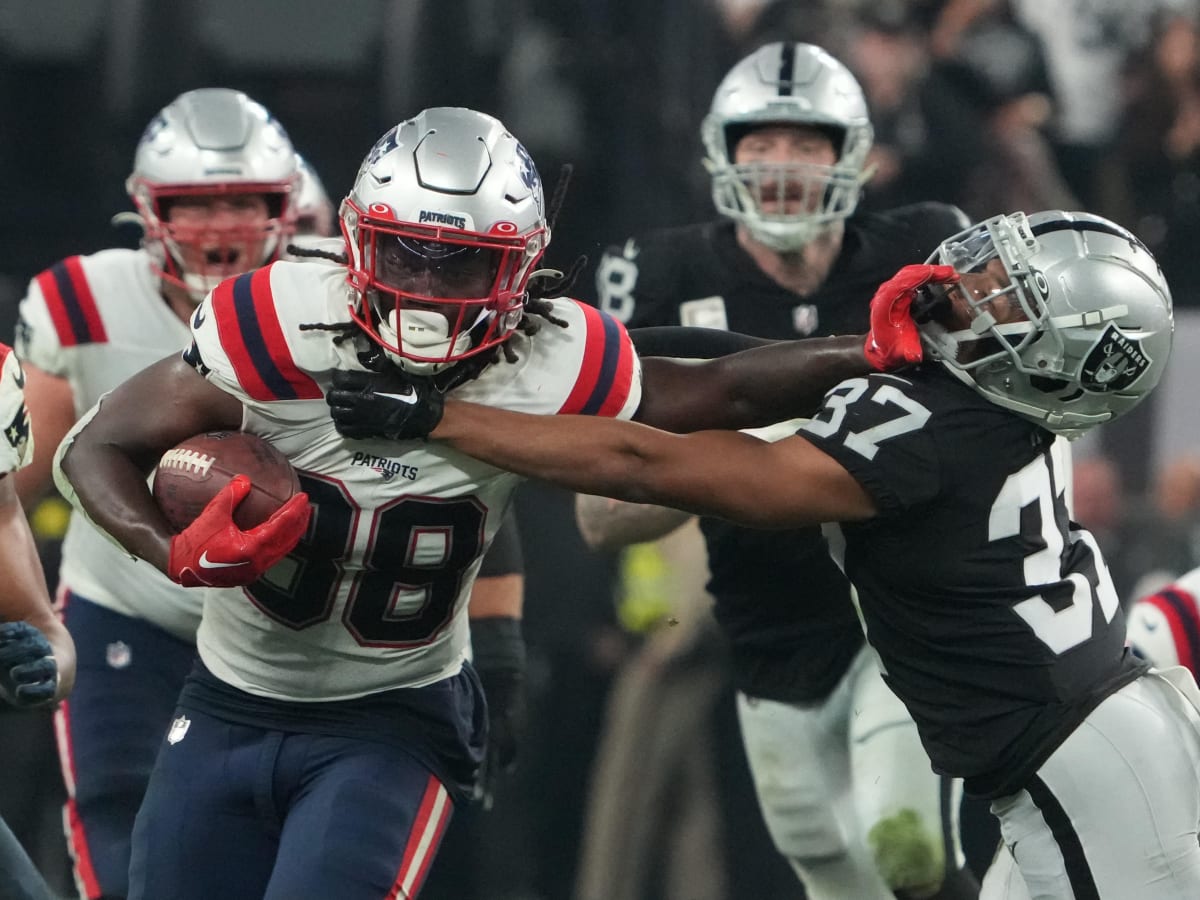 Rhamondre Stevenson of the New England Patriots runs past Jeff