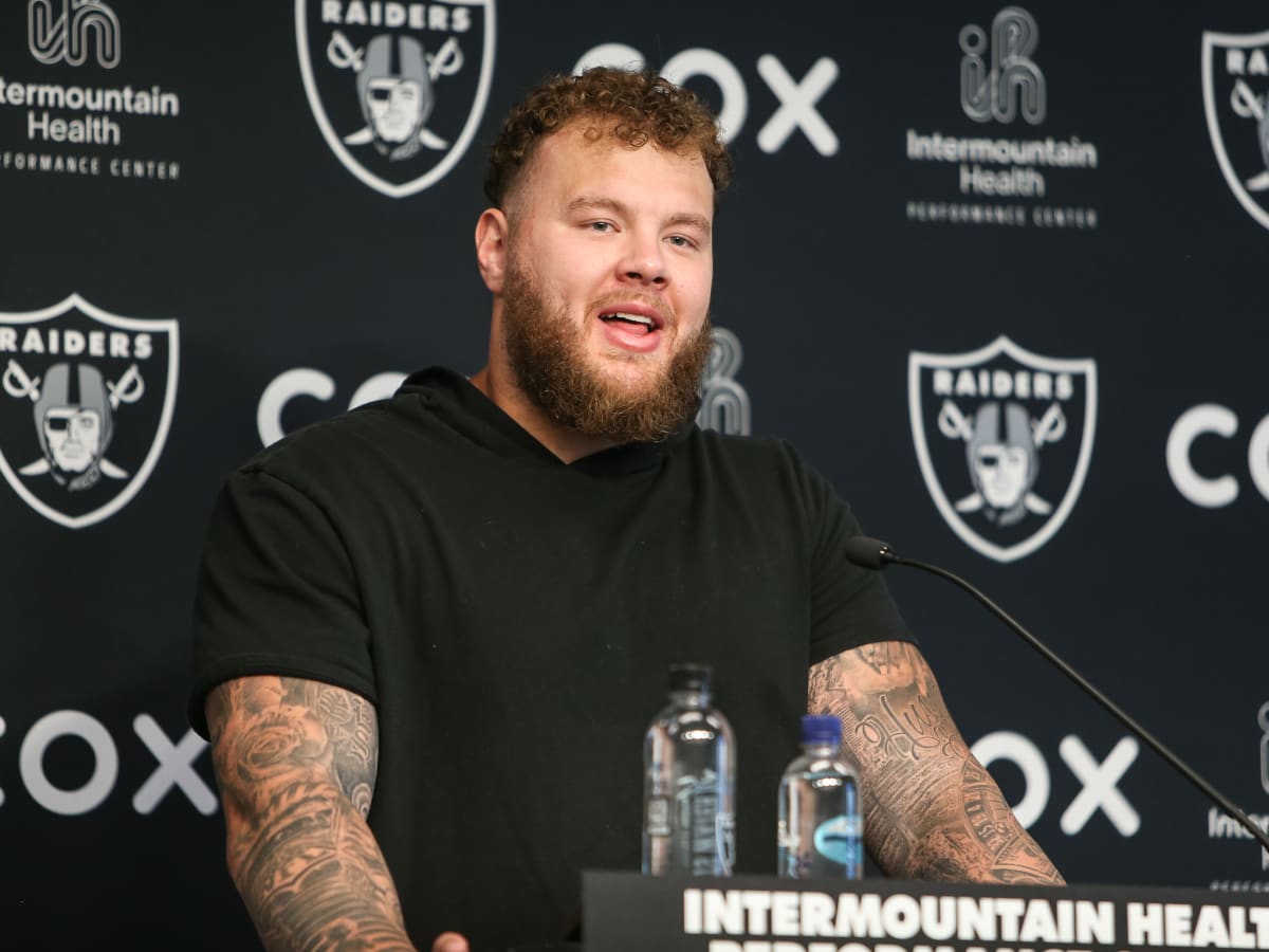 Las Vegas Raiders center Andre James walks with trainers after an