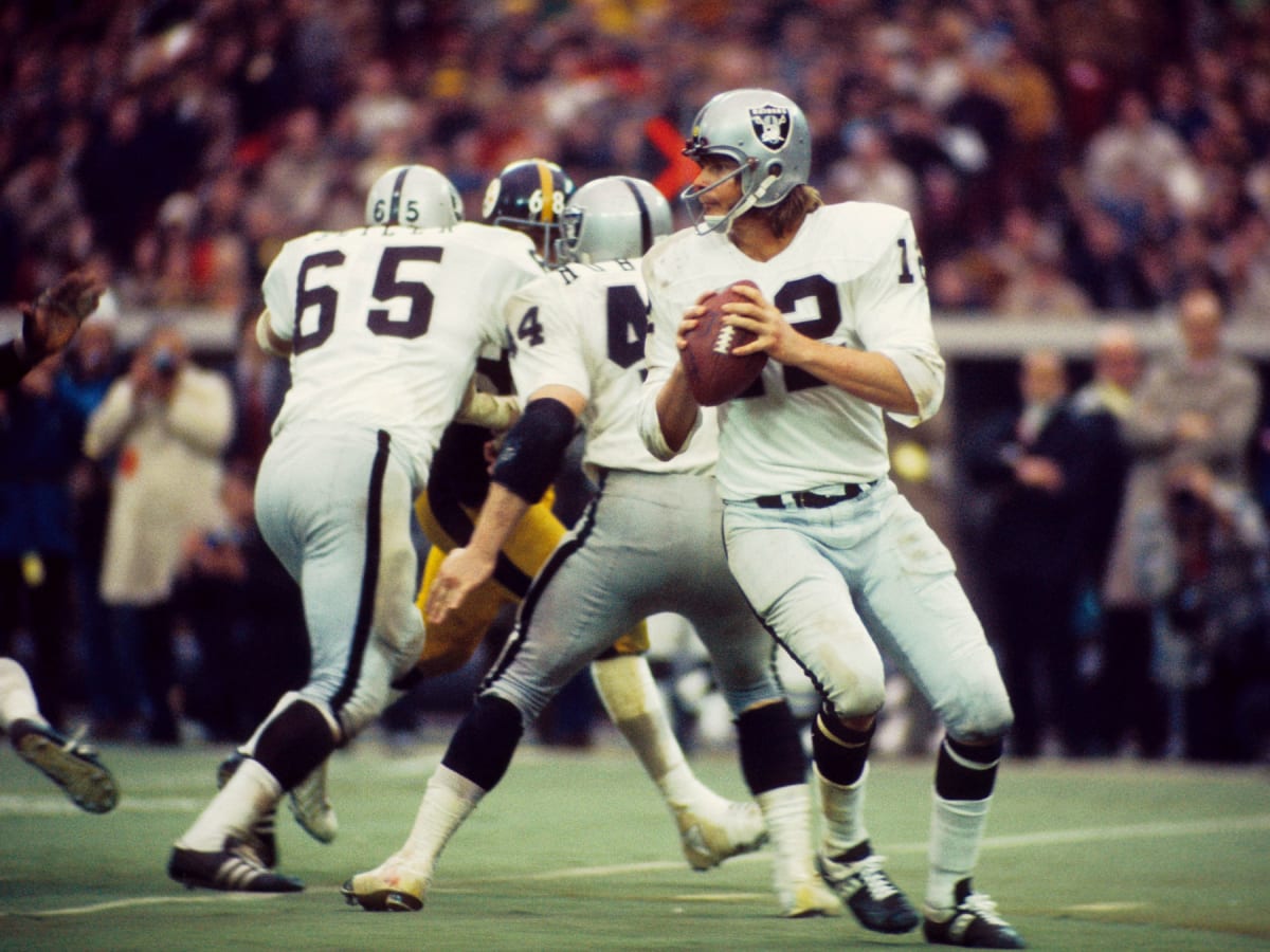 Oakland Raiders tight end Dave Casper, left, carries the ball