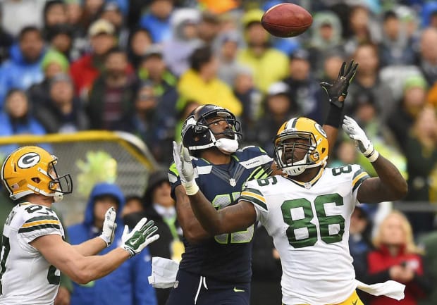 Seattle Seahawks Kam Chancellor, left and Russell Wilson, right, hold a 12th  Man flag after beating the Green Bay Packers 28-22 for the NFC Championship  at CenturyLink Field in Seattle, Washington on