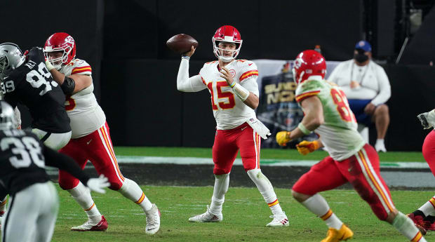 Kansas City Chiefs quarterback Patrick Mahomes (15) throws a pass as  Arizona Cardinals defensive tackle Corey Peters (98) closes in, during the  first half of an NFL football game in Kansas City