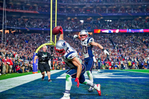 Willie McGinst, of the New England Patriots, holds up the AFC Championship  Trophy, as he walks around the field, at Gillette Stadium, following the  Patriots victory of the Indianapolis Colts, in the