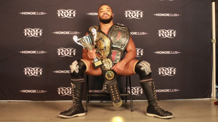 Ring of Honor wrestler Jonathan Gresham poses with his championship belts