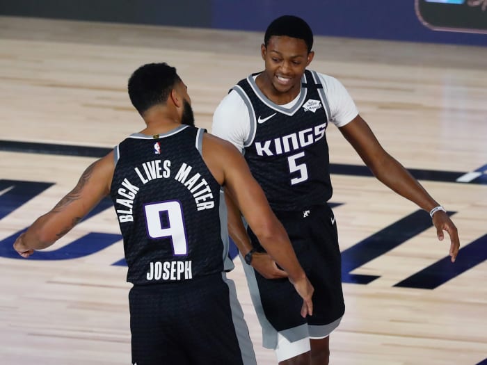 Acramento Kings guard Cory Joseph (9) and guard De'Aaron Fox (5) celebrate during the first half of an NBA basketball game against the Dallas Mavericks