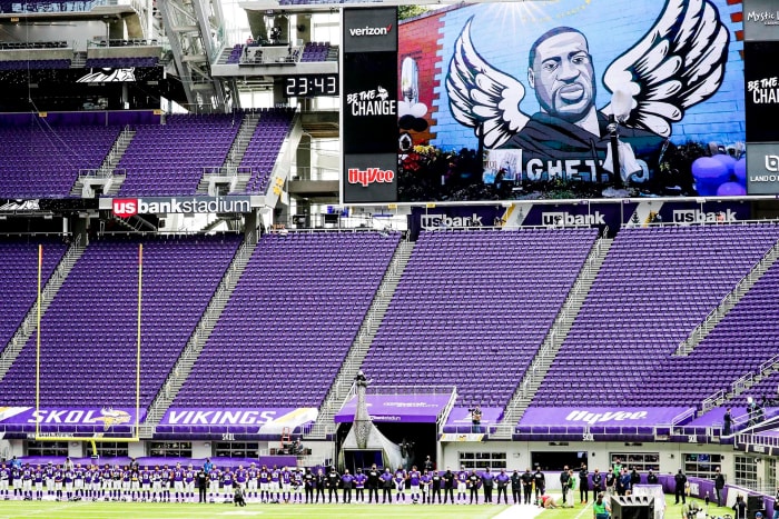 A mural of George Floyd on the video screen and a stadium full of empty seats at the Vikings' season opener