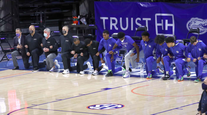 Kentucky Wildcats coaches and players kneel during the national anthem ahead of a game against the Florida Gators on January 9, 2021.