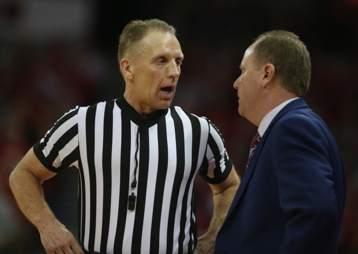 NCAA referee Mike Eades talks to Wisconsin Badgers head coach Greg Gard during the game with the Minnesota Gophers at the Kohl Center. Mandatory Credit: Mary Langenfeld-USA TODAY Sports