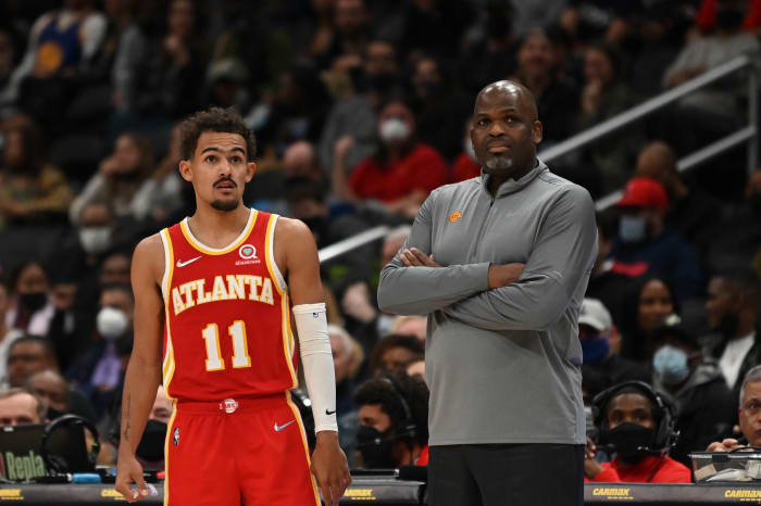 Trae Young standing beside Nate McMillan.