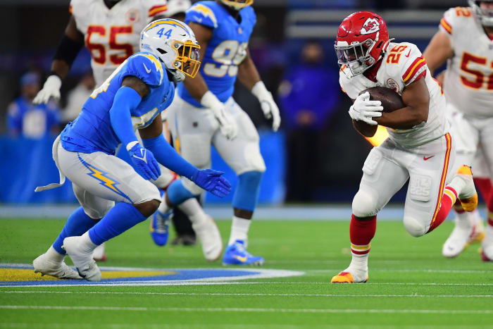 16 de diciembre de 2021;  Englewood, CA, Estados Unidos;  Kansas City Chiefs volver corriendo Clyde Edwards Heller (25) ejecuta el balón contra Los Angeles Chargers fuera de operación Linebacker Keizer White (44) durante la primera mitad en Sophie Stadium.