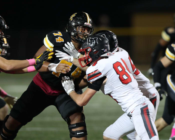 Southeast Polk's Kadyn Proctor (74) tries to keep Linn-Mar defenders away from his quarterback Friday in Pleasant Hill.