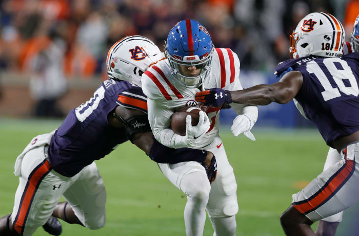 Oct 30, 2021; Auburn, Alabama, USA; Mississippi Rebels wide receiver John Rhys Plumlee (10) is tackled by Auburn Tigers cornerback Nehemiah Pritchett (18) and safety Zion Puckett (10) during the second quarter at Jordan-Hare Stadium. Mandatory Credit: John Reed-USA TODAY Sports