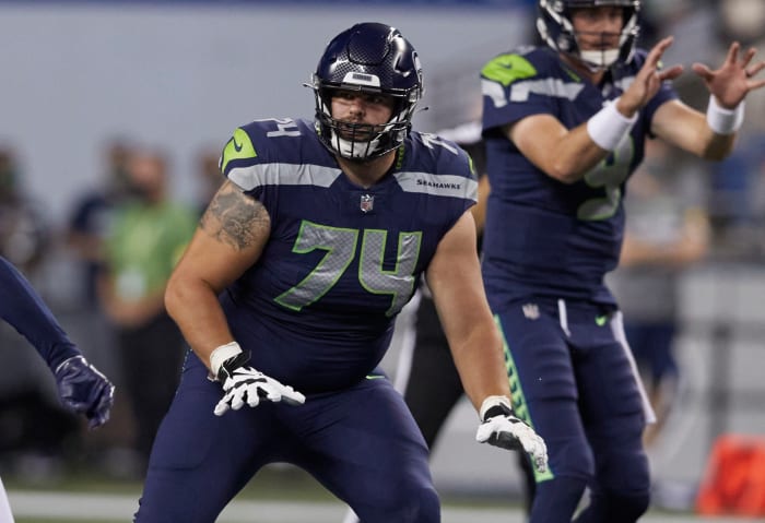 Seattle Seahawks' Jake Curhan on the line of scrimmage as the ball is snapped to quarterback Sean Mannion against the Denver Broncos during the second half of an NFL football preseason game, Saturday, Aug. 21, 2021, in Seattle. The Broncos won 30-3.