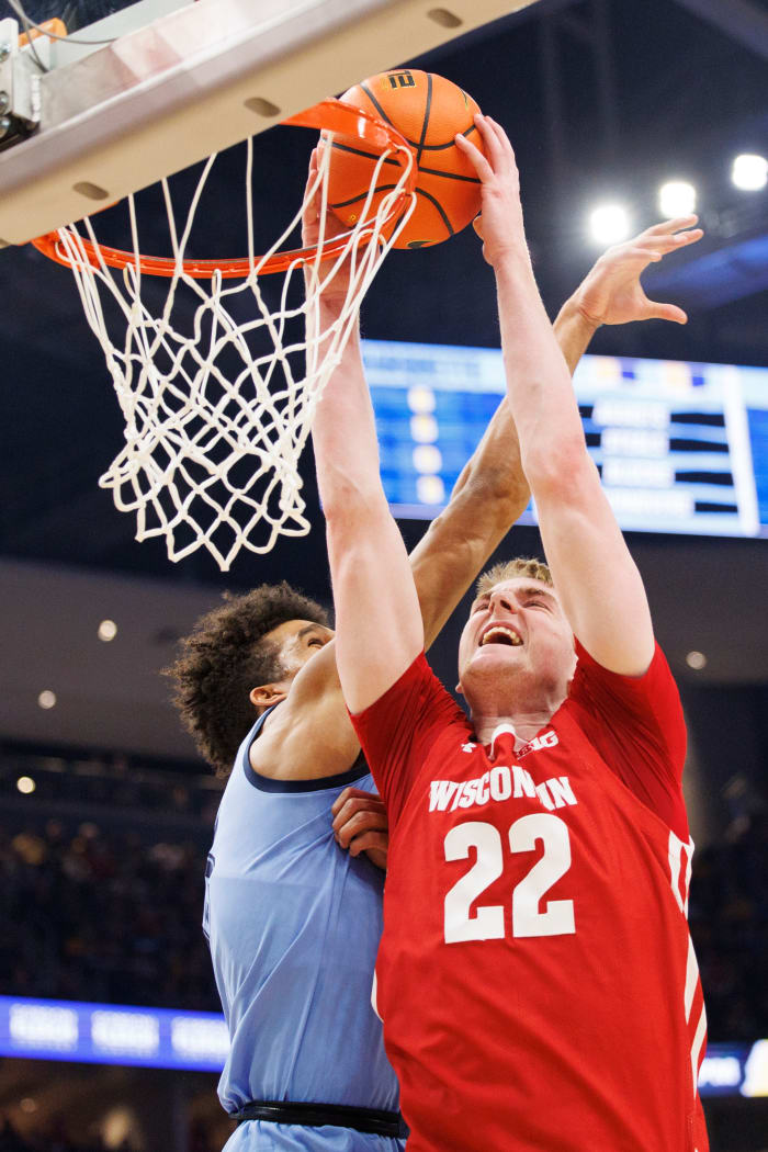 Wisconsin forward Steven Crowl dunking the basketball through traffic against Marquette.