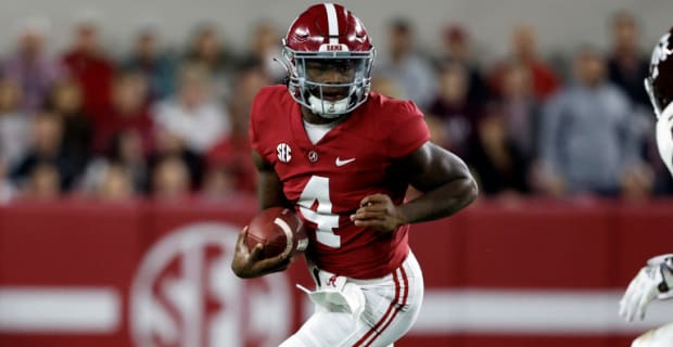 Alabama Crimson Tide quarterback Jalen Milroe makes a rushing attempt during a college football game in the SEC.