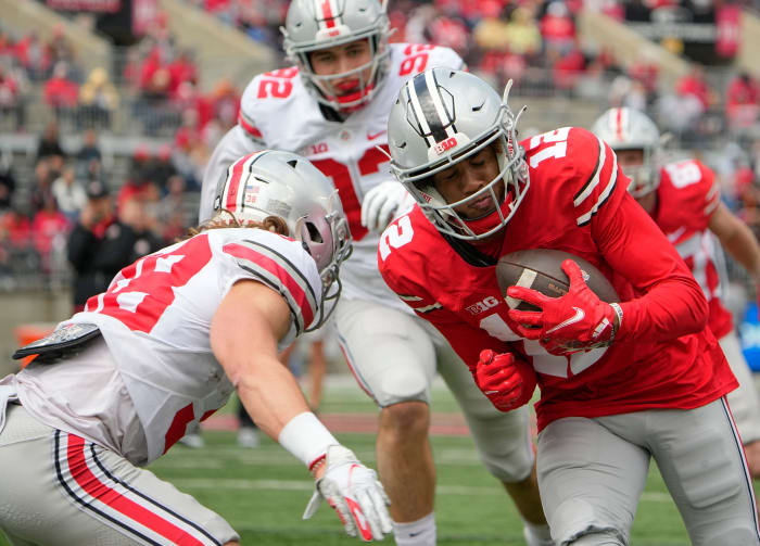 Ohio State Buckeyes wide receiver Caleb Burton (12) braces for impact with cornerback Cameron Kittle (38) during the spring football game at Ohio Stadium in Columbus on April 16, 2022. Ncaa Football Ohio State Spring Game