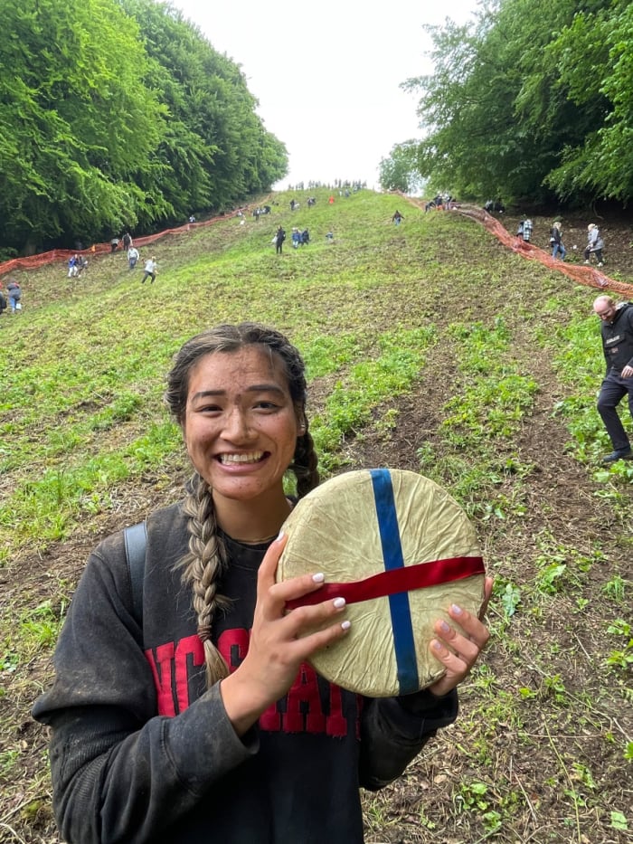 Abby Lambi, 21 ans, tient du fromage après avoir remporté le Copper Hill Cheese Roll dimanche dans le Gloucestershire, en Angleterre.