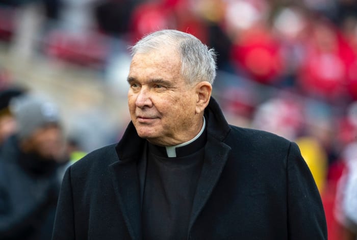 Father Mike walking on the field of Camp Randall Stadium.