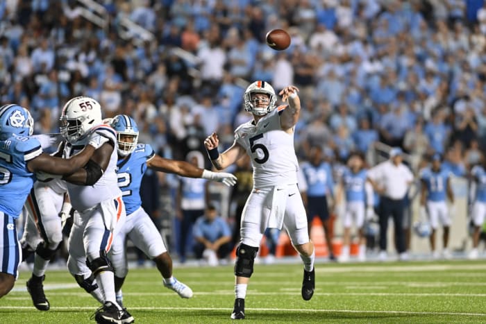 Virginia Cavaliers quarterback Brennan Armstrong (5) passes the ball as North Carolina Tar Heels linebacker Tomon Fox (12) pressures in the second quarter at Kenan Memorial Stadium.