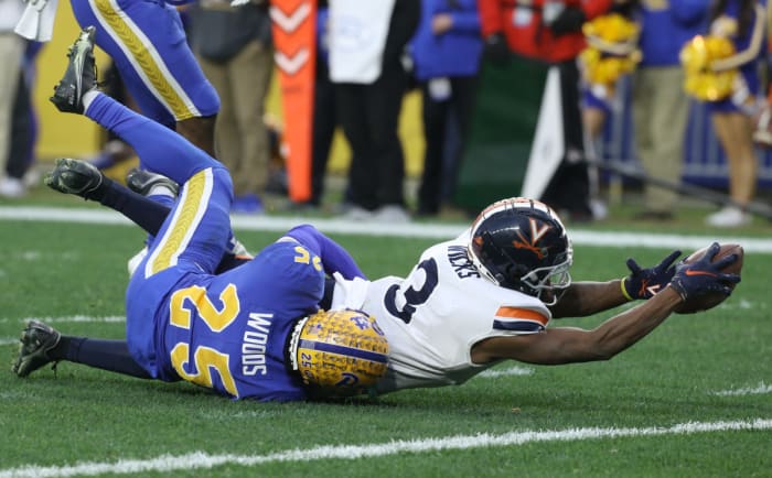 Virginia Cavaliers wide receiver Dontayvion Wicks (3) reaches for extra yardage after a catch against Pittsburgh Panthers defensive back A.J. Woods (25) during the second quarter at Heinz Field.