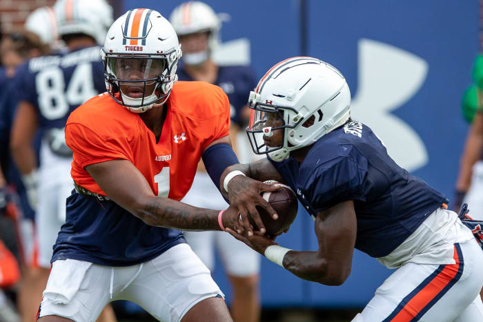 TJ Finley (1) hands off to Tank Bigsby (4) during practice.