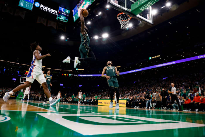 Guard Boston Celtics Jaylen Brown (7) melakukan dunk melewati guard Philadelphia 76ers Tyrese Maxey (0) pada kuarter ketiga di TD Garden.