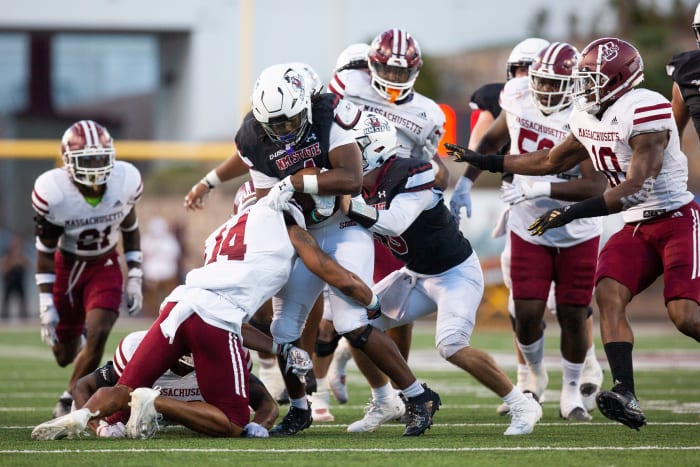 UMass defense players tackle NMSU running back Star Thomas during an Aggie football game on Saturday, August 25, 2023, at the Aggie Memorial Stadium.