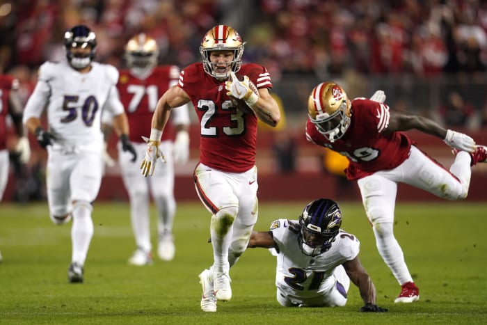 December 25, 2023;  Santa Clara, California, USA;  San Francisco 49ers running back Christian McCaffrey (23) runs the ball under pressure from Baltimore Ravens cornerback Brandon Stephens (21) in the second quarter at Levi's Stadium.  Mandatory Credit: Cary Edmondson-USA TODAY Sports