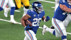 New York Giants volver corriendo Saquon Barkley (26) lleva el balón contra los Pittsburgh Steelers como guardia ofensivo Kevin Zeitler (70) bloquea durante la segunda mitad en el MetLife Stadium.