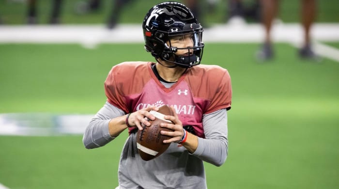 El mariscal de campo de Cincinnati, Desmond Ridder, busca un receptor abierto durante la práctica para el partido de fútbol americano Cotton Bowl de la NCAA, el lunes 27 de diciembre de 2021, en Arlington, Texas.