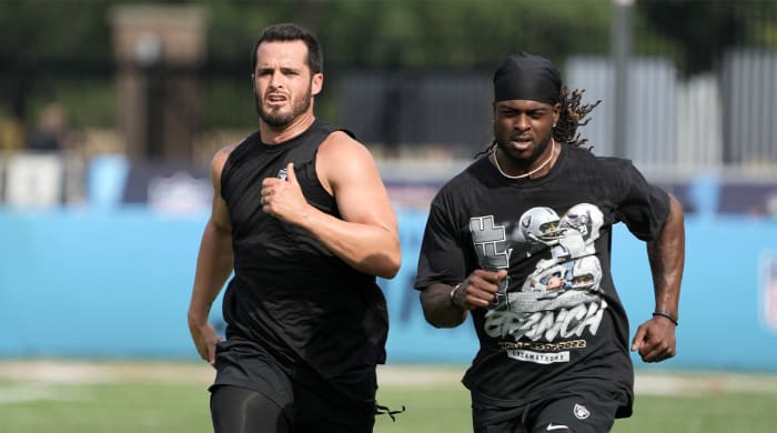 Aug 4, 2022;  Canton, Ohio, USA;  Las Vegas Raiders receiver Davante Adams (left) and quarterback Derek Carr run before the game against the Jacksonville Jaguars at Tom Benson Hall of Fame Stadium.