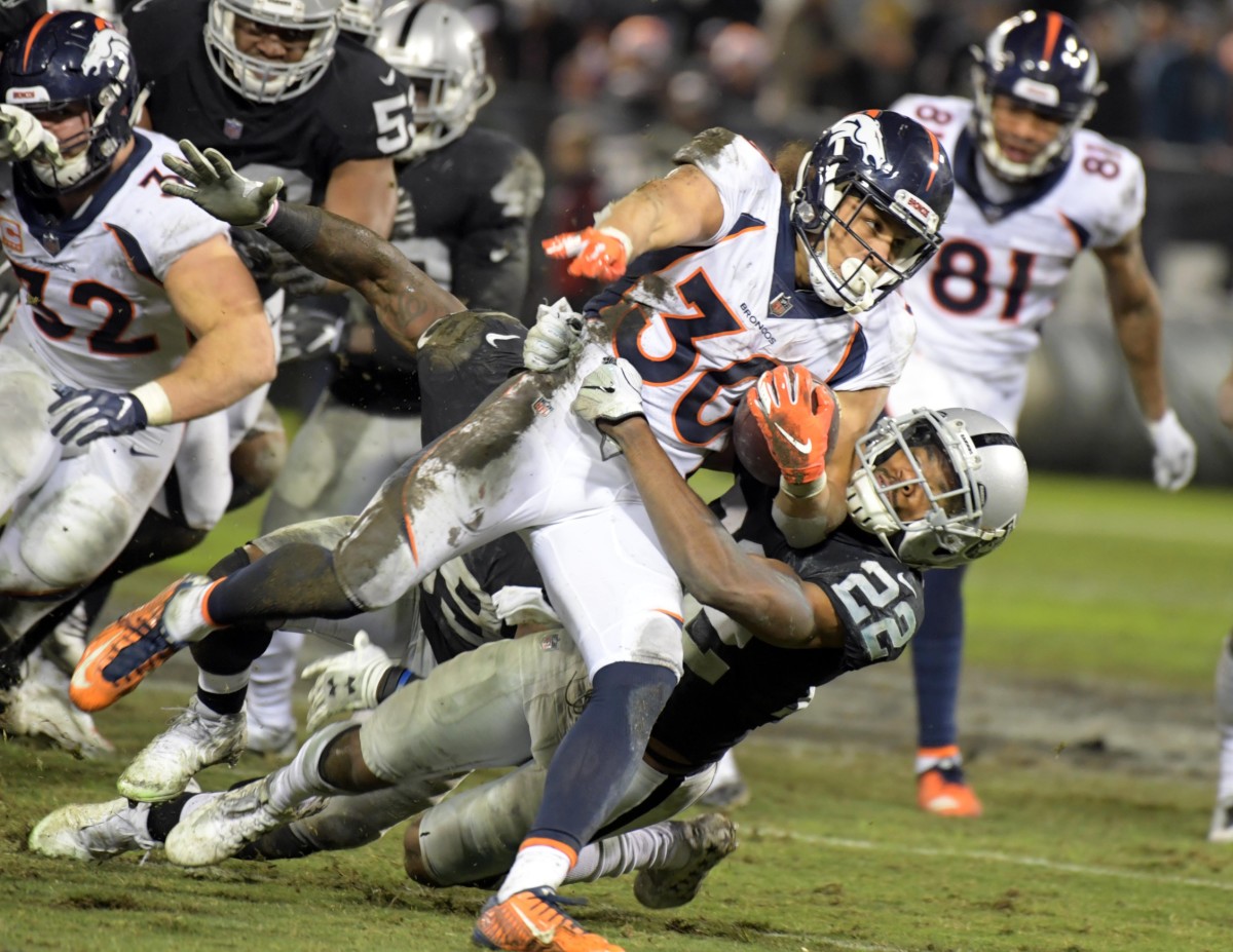 Denver Broncos running back Phillip Lindsay (30) is tackled by Oakland Raiders cornerback Rashaan Melvin (22) in the second half at Oakland Coliseum.