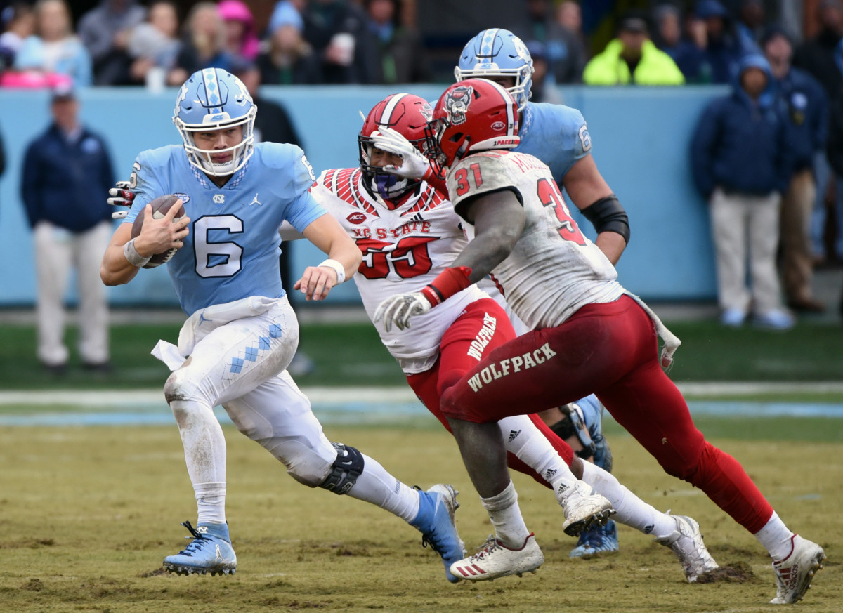 Deonte Holden (55) and teammate Jarius Morehead (31) chase down UNC quarterback Cade Fortin during a game last season