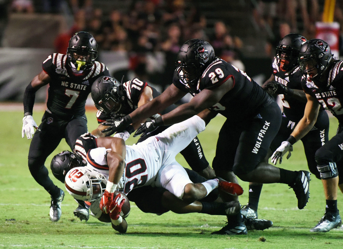 Wolfpack defenders gang tackle Ball State running back Walter Fletcher during Saturday's win at Carter-Finley Stadium