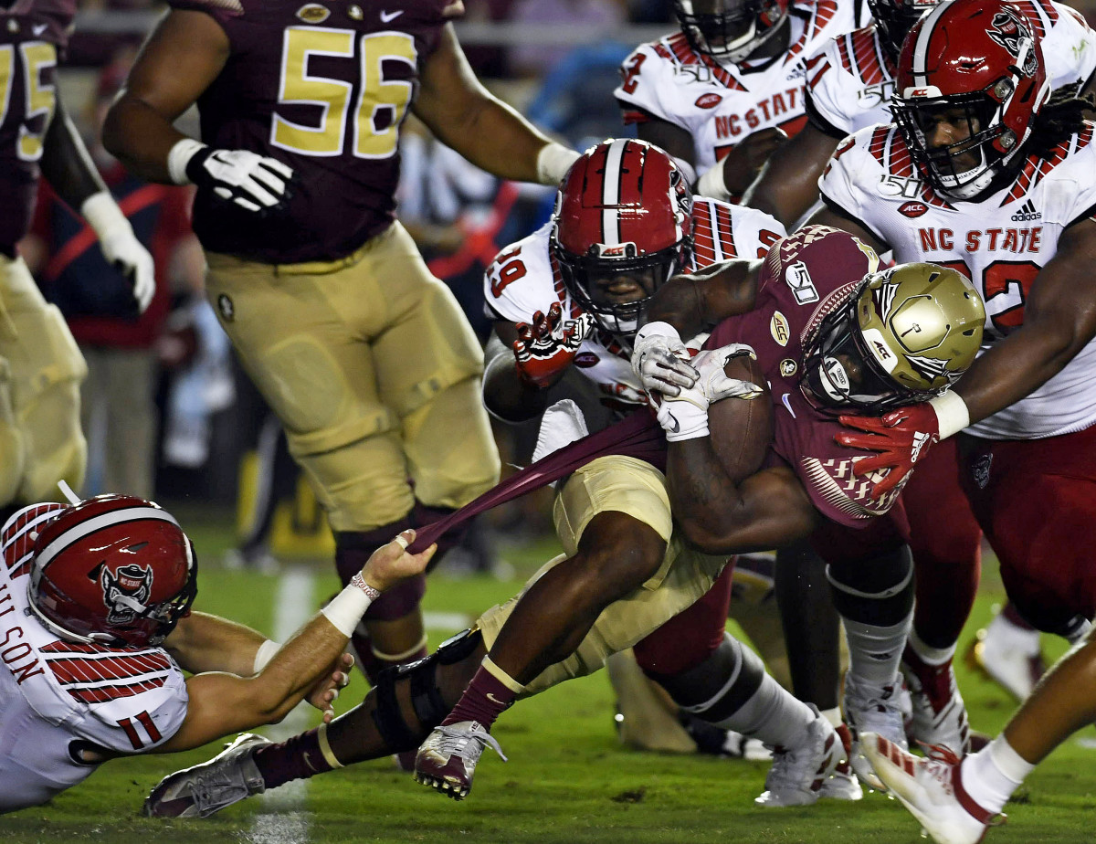 Larrell Murchison (92), Alim McNeill (29) and Payton Wilson (11) combine to stop FSU running back Cam Akers