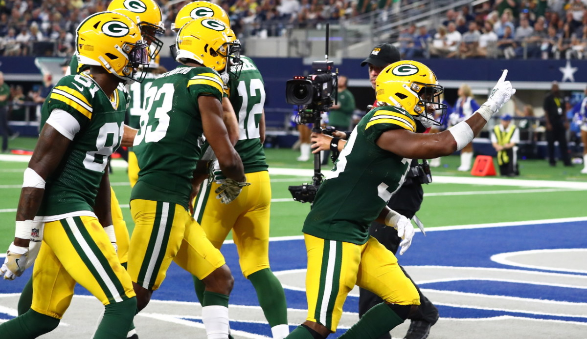 Dallas Cowboys' running back Emmitt Smith adjusts his mouth guard as he  checks the replay from the bench, in the second quarter against the Green  Bay Packers during their NFC playoff game