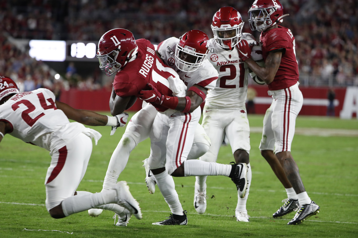 Henry Ruggs III tries to a shake a tackler against Arkansas