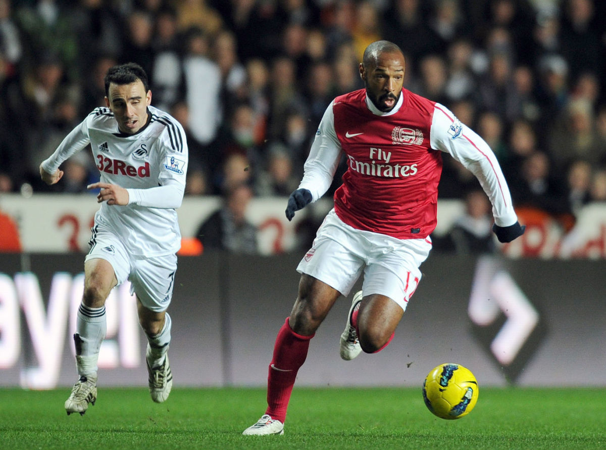 Swansea City's Leon Britton (L) chases a