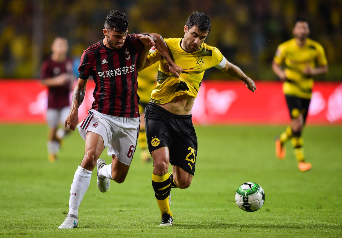 Borussia Dortmund's Sokratis Papastathopoulos (R) competes for the ball with AC Milan's Patrick Culrone during their International Champions Cup football match in Guangzhou, in China's southern Guangdong province on July 18, 2017. / AFP PHOTO / STR / China OUT        (Photo credit should read STR/AFP/Getty Images)