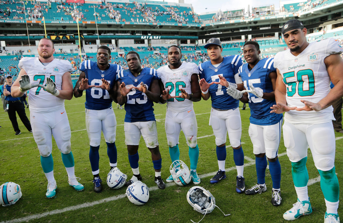 Vernon (50) poses with fellow former Miami Hurricanes (from left) Jason Fox, Andre Johnson, Frank Gore, Lamar Miller,  Stephen Morris and Phillip Dorsett after the Week 16 Colts-Dolphins game. 