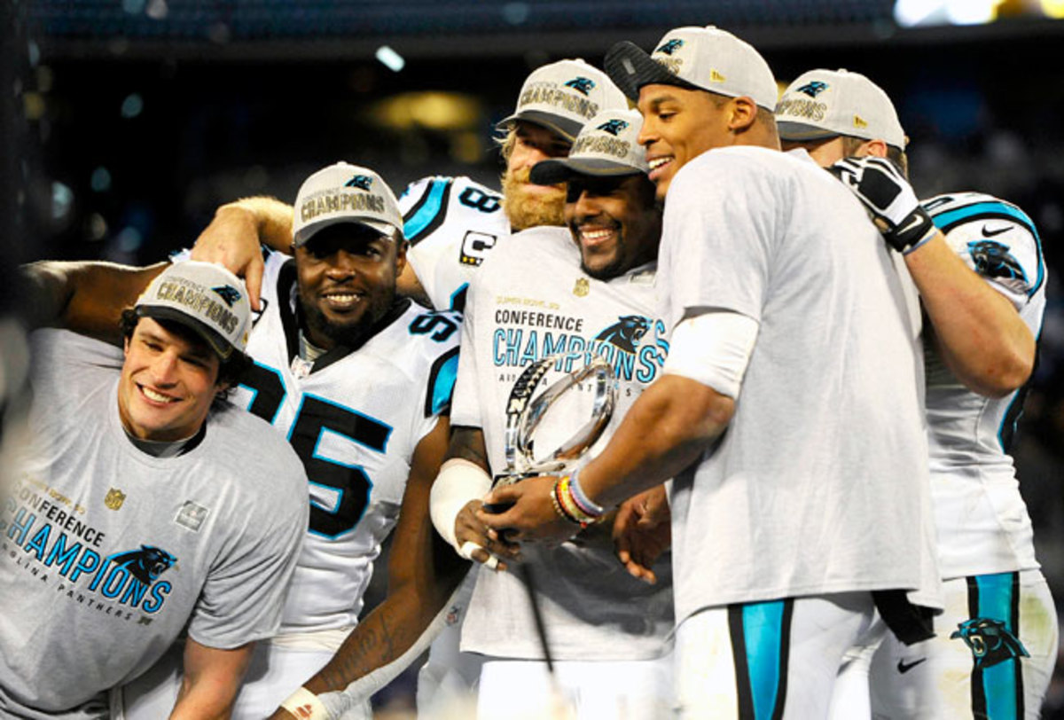 Carolina Panthers linebacker Thomas Davis lifts the NFC championship trophy  as he and defensive end Charles Johnson, left, celebrate after the Panthers  defeat the Arizona Cardinals 49-15 at Bank of America Stadium