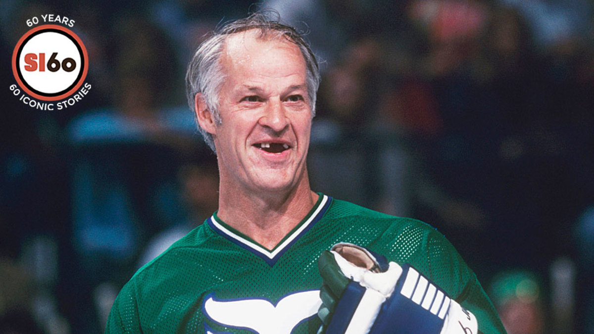 Gordie Howe, second from left, looks over his wife, Colleen's, New England  Whalers jersey at a news conference on Monday, May 23, 1977 in Hartford,  where the Whalers announced that Gordie and