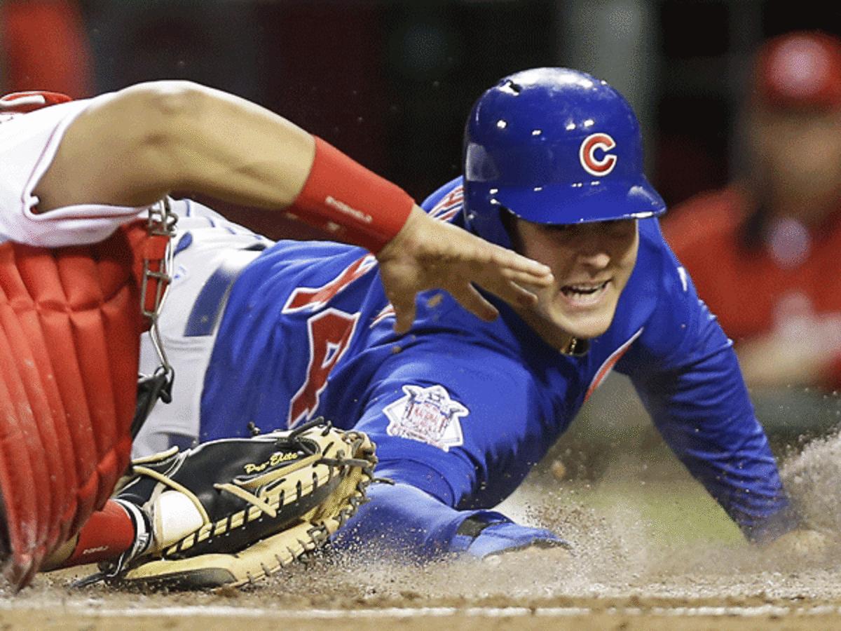 Anthony Rizzo dives in to score one of his three runs on Wednesday night against the Reds. (AP)