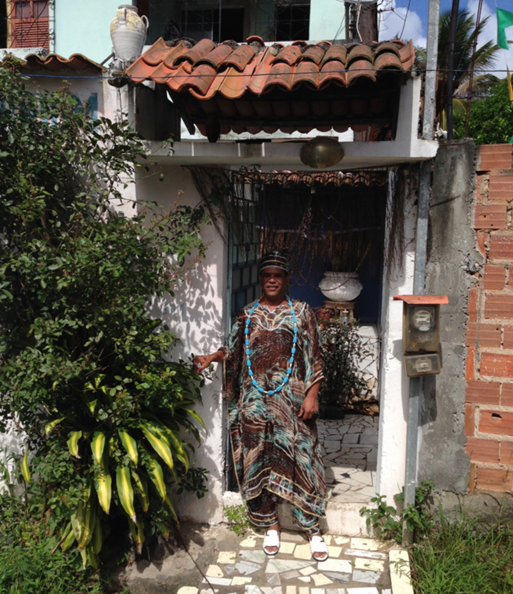 Gilson Ferreira dos Santos, a Pai de Santo in Candomble, the mystical Brazilian religion, sits outside his home in Salvador. 