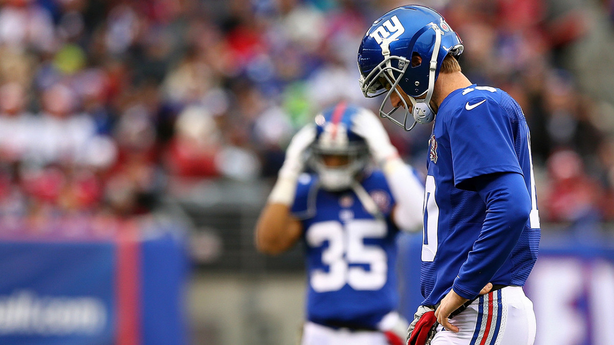 New York Giants runningback Tiki Barber takes a hand off from Eli Manning  in week 13 at Giants Stadium in East Rutherford, New Jersey on December 4,  2005. The New York Giants