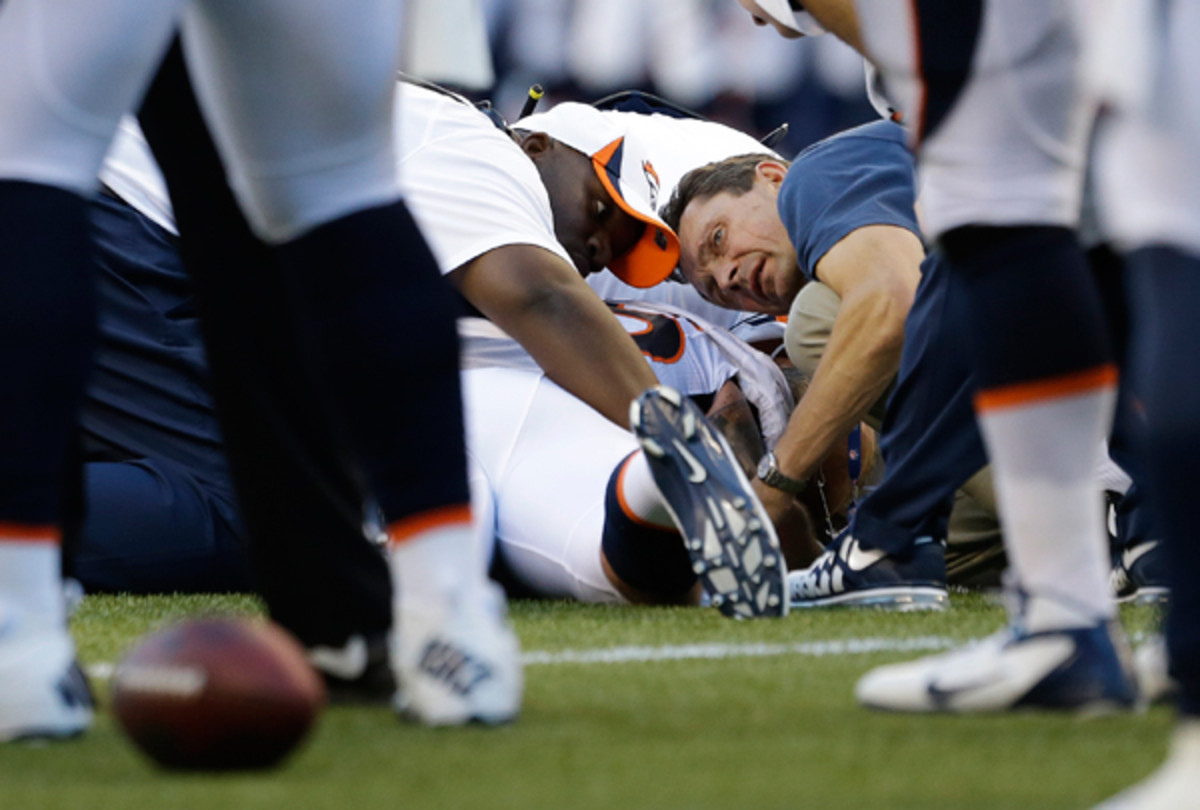 The Denver Broncos' medical staff examines Derek Wolfe after a first-quarter injury. (Elaine Thompson/AP)