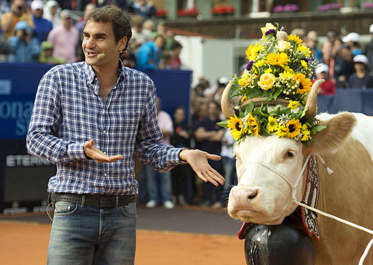 Roger Federer appears completely thrilled with his gift of a cow, since that's a perfectly normal way to thank someone. (PETER SCHNEIDER/EPA)