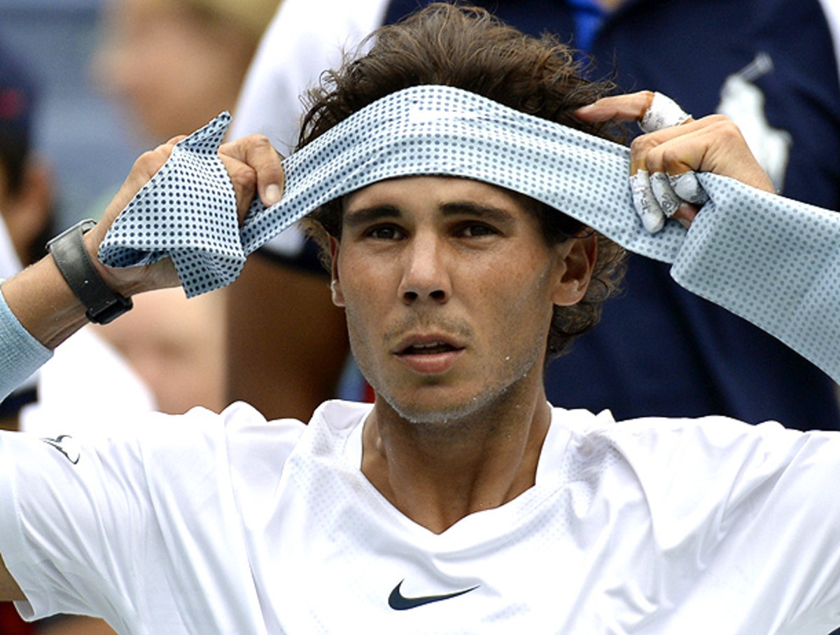 Rafael Nadal replaces his headband during his first round match. (Timothy Clarey/AFP/Getty Images)