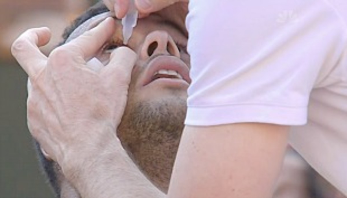 Tsonga gets eye-drops from the trainer before the third set. (Screengrab from NBCSports.com)