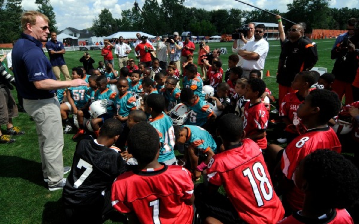 NFL Commissioner Roger Goodell talks with youth football players. (Tom E. Puskar/ AP Images for NFL Network)